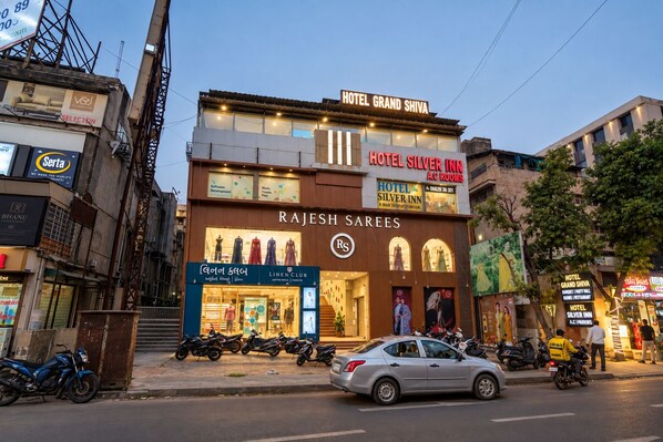 A building with multiple signs for Hotel Grand Shiva, Hotel Silver Inn, and Rajesh Sarees. - HOTEL GRAND SHIVA (Ahmedabad)