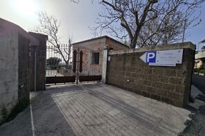 A gated parking area with a sign indicating 'Parking Santa Maria' and 'PARKING NON CUSTODITO.' - Grazy Home | Private Terrace, Summer Pool & Relaxation in Vico Equense (Vico Equense)