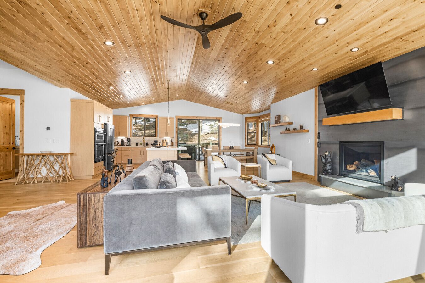 Un vaste espace de vie au design moderne, comprenant un grand canapé, une table basse et une cheminée.