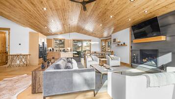 Un vaste espace de vie au design moderne, comprenant un grand canapé, une table basse et une cheminée.