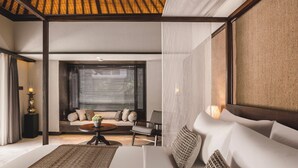 A modern bedroom with a large bed, a sofa, and a coffee table. - Taman Estate by Ekosistem (Seminyak)