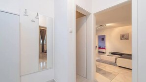 Ein modernes Hotelzimmer mit einem großen Spiegel, einer Couch und einem kleinen Tisch.