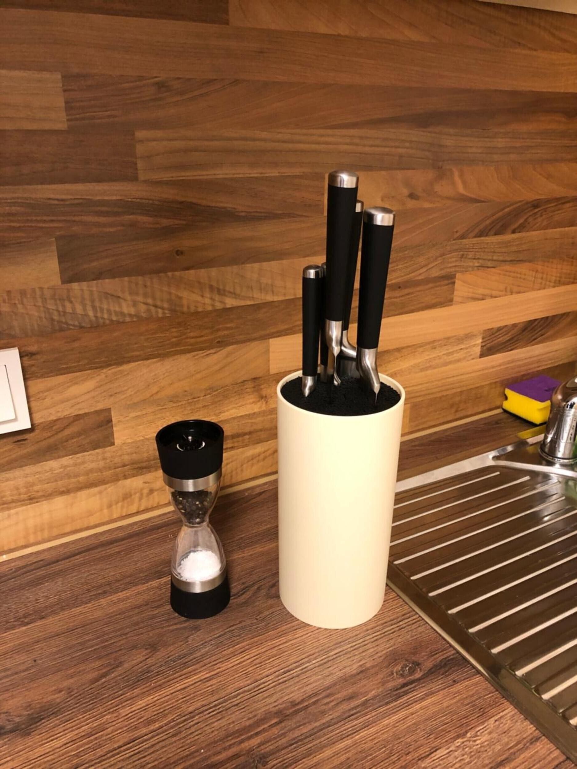 A kitchen counter with a salt shaker, a pepper shaker, and a knife block.