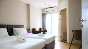 Een hotelkamer met twee bedden, een bureau en een stoel.