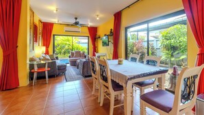 Un comedor con una mesa y sillas, un sofá y vistas al exterior.