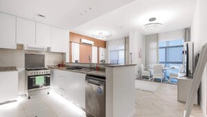 Une cuisine moderne dotée d’un îlot central, d’un four encastré et d’un coin repas offrant une vue agréable.