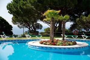 A pool with a circular island surrounded by lounge chairs and a lifebuoy. - 47.00 S Agaro  Las Velas 2 9 Fantastic apartment with Sea views (Sant Feliu de Guixols)