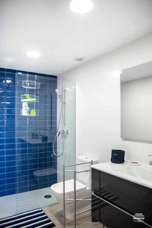 A modern bathroom with a glass shower enclosure, a white toilet, and a black vanity with a mirror. - 47.00 S Agaro  Las Velas 2 9 Fantastic apartment with Sea views (Sant Feliu de Guixols)