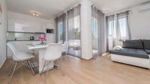 A modern apartment with a kitchen, dining area, and living room. - Villa Star 1 (Novalja)