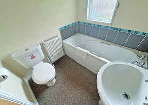 Un baño con inodoro, bañera y lavamanos.