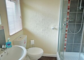A bathroom with a toilet, sink, and shower.