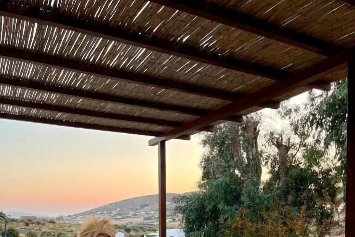 Un patio in pietra con ringhiera in legno e vista su un paesaggio collinare.
