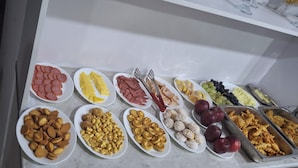 A buffet with various food items including fruits, cheeses, and pastries. - OKS hotel (Tashkent)