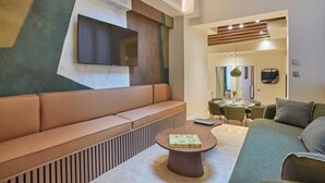 Una sala de estar moderna con un sofá, una mesa de centro y un televisor montado en la pared.