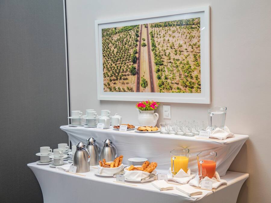 A breakfast buffet with coffee, tea, pastries, and juice.