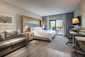 A modern hotel room with a bed, a sofa, a desk, and a TV. - Holiday Inn & Suites Aguascalientes (Aguascalientes)