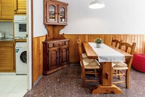 A compact kitchen with wooden cabinets, a built-in oven, and a washing machine. - 27.40 Polcent 5 S'Agaró  apartment close to the beach (Sant Feliu de Guixols)
