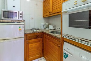 A compact kitchen with a microwave, toaster, coffee maker, and a Hisense refrigerator. - 27.40 Polcent 5 S'Agaró  apartment close to the beach (Sant Feliu de Guixols)