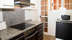 Una cucina con piani di lavoro in granito, piano cottura integrato e forno a microonde.