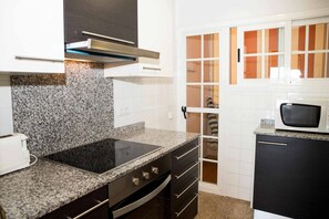A kitchen with granite countertops, a built-in stove, and a microwave. - 42.00 S'Agaró Caoca A6  Apartment with beautiful views (Sant Feliu de Guixols)