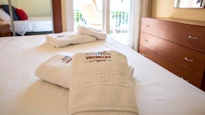Una camera d'albergo con un letto, un comò in legno e vista su un balcone.