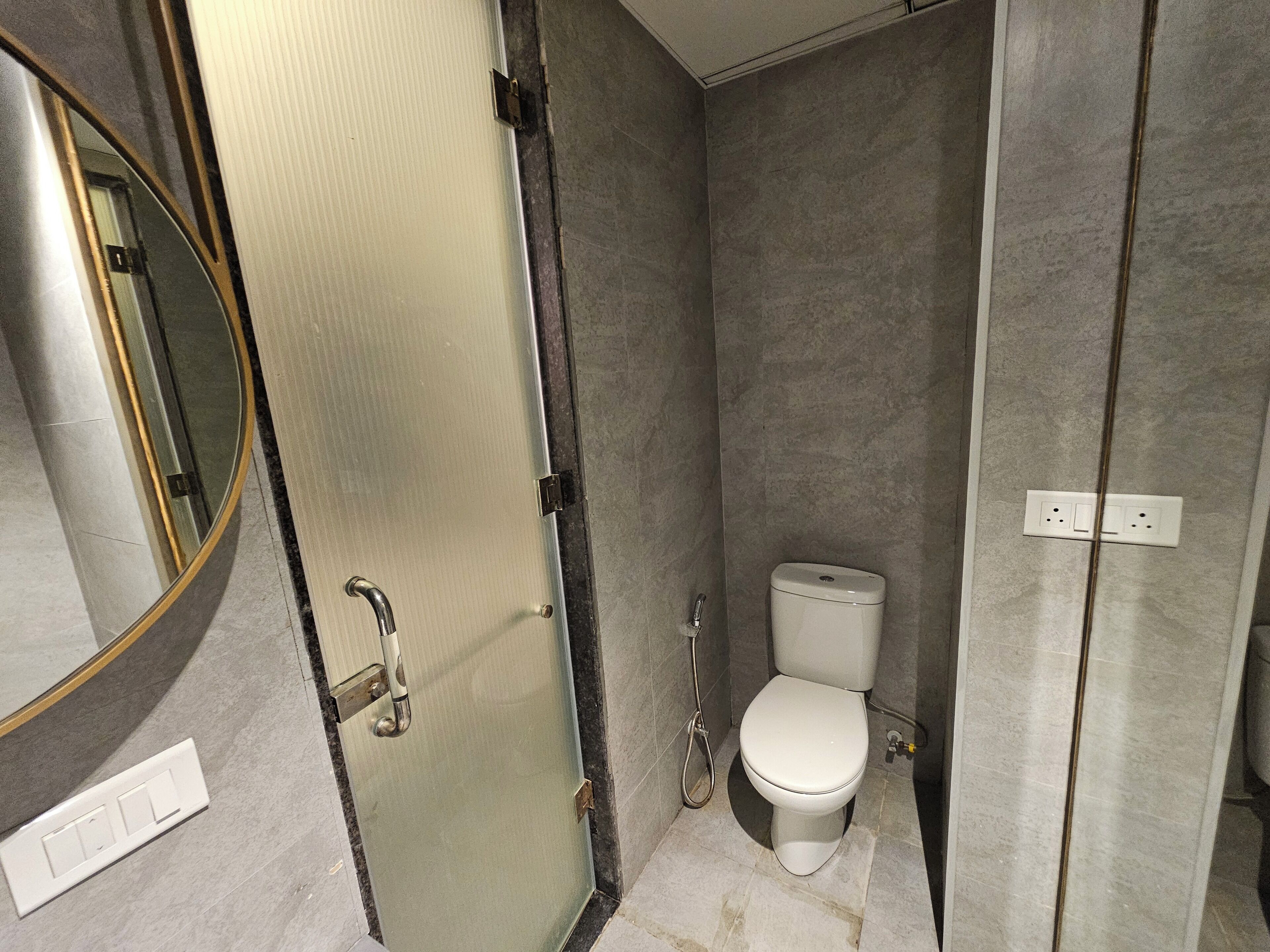 Un baño con inodoro, ducha y espejo.