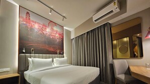Een moderne hotelkamer met een groot bed, een bureau en een stoel.