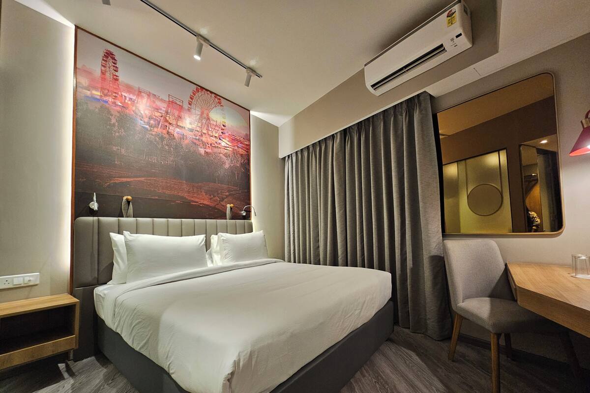 Une chambre d’hôtel moderne, dotée d’un grand lit, d’un bureau et d’une chaise.