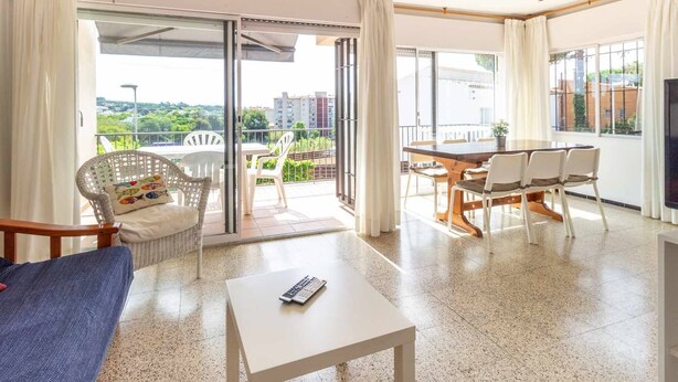 A spacious living area with a balcony, a dining table, and a sofa. - 24.40 Carrilet 37 pis  S'Agaró Nice apartment (Sant Feliu de Guixols)