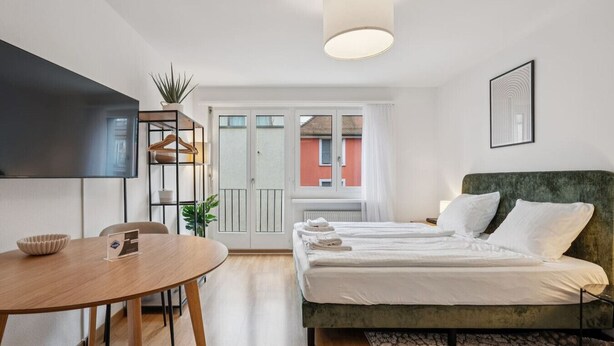 Une chambre moderne équipée d’un lit, d’un bureau et d’une télévision.