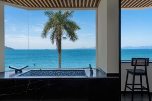 Un baño con un ventanal amplio, un lavamanos de mármol y una silla.