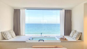 Un dormitorio con un ventanal grande, una bañera y una cama.