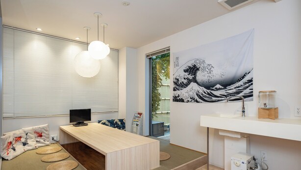 Un intérieur moderne avec un comptoir d’accueil en bois, une œuvre d’art accrochée au mur et une prise électrique visible.