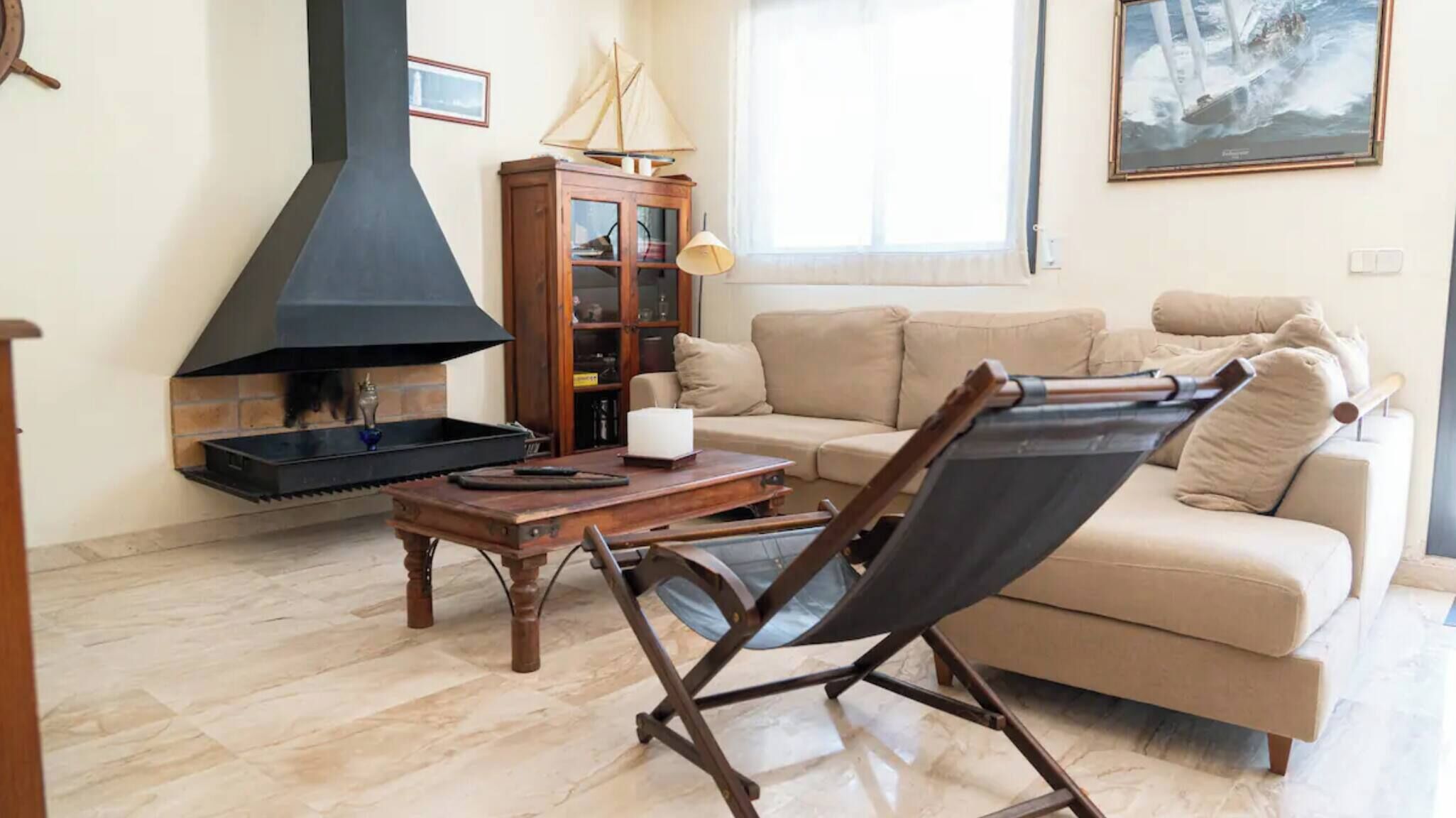Un salon avec une cheminée, un canapé, une table et une chaise pliante.