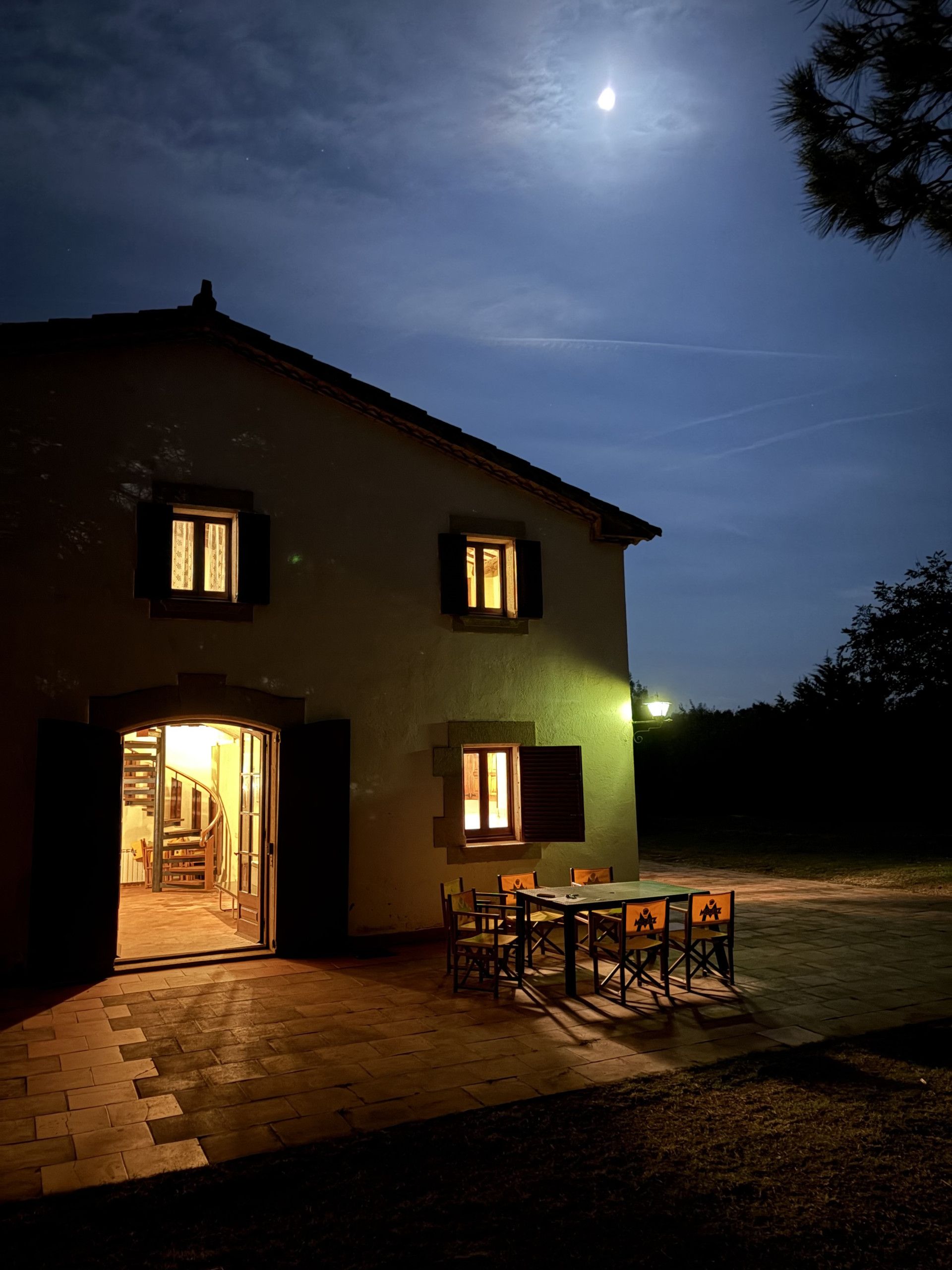 Une maison à deux étages avec un patio et une table à manger.
