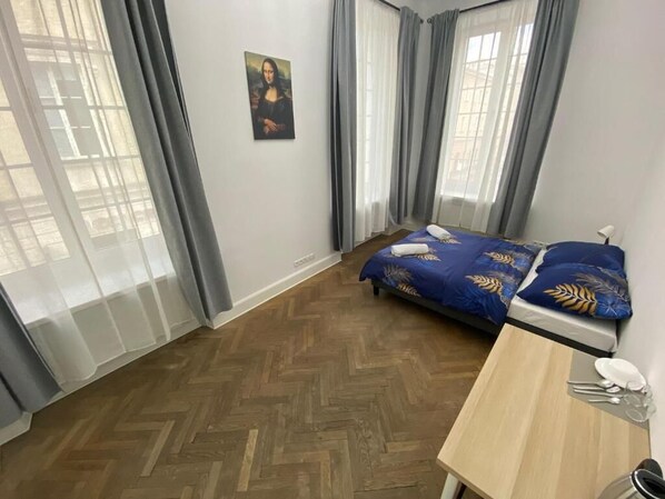 A bedroom with a bed, a desk, and a chair. - Fantastic Inn Warsaw - NS51 (Warsaw)