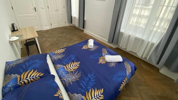 Un dormitorio con cama, escritorio y un cuadro en la pared.