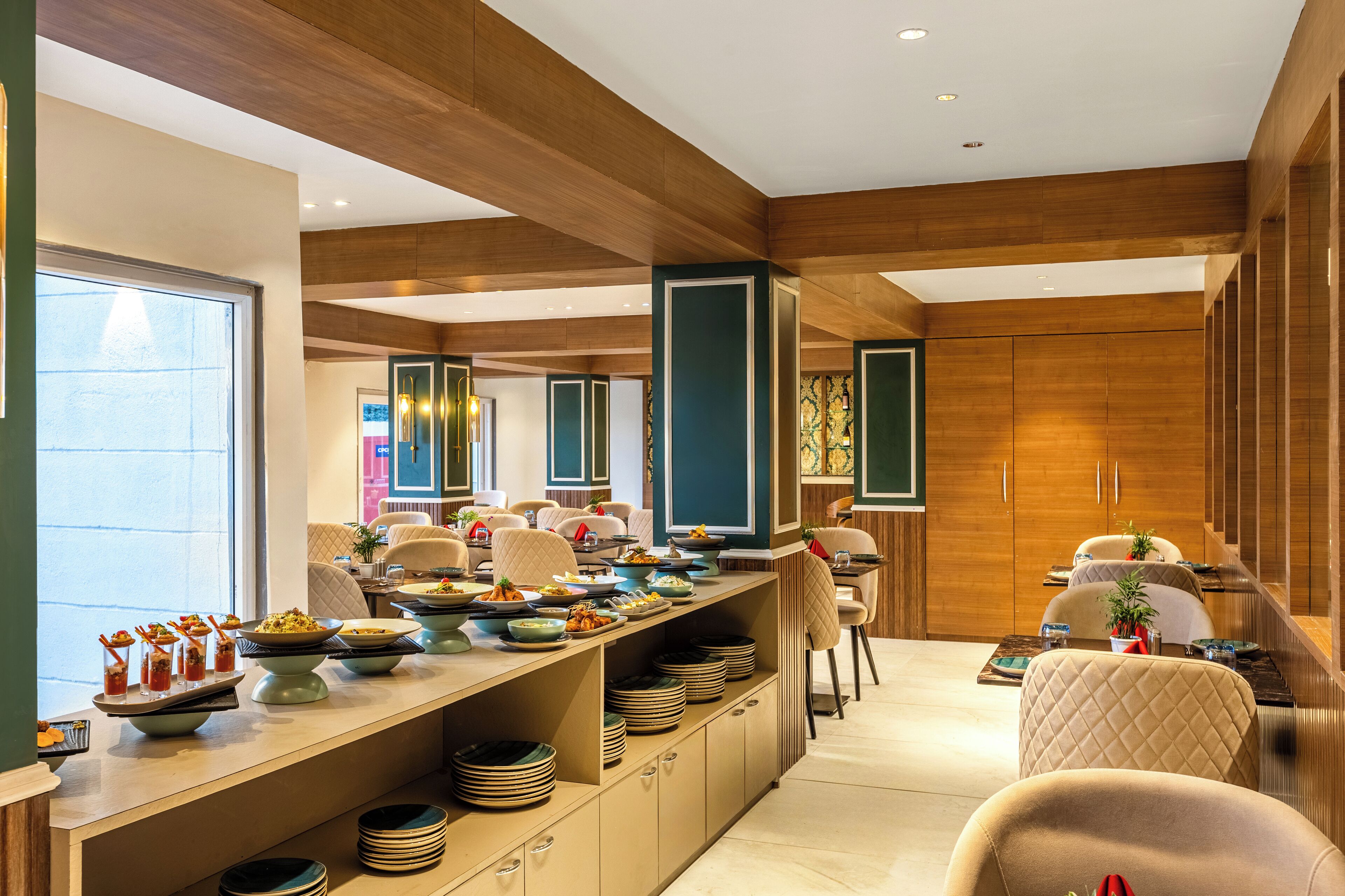 A modern dining area with a long counter, multiple seating options, and a view of the adjacent room.