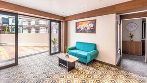 A reception area with a blue sofa, a coffee table, and a painting on the wall. - Sterling Mount Olive Gangtok (Gangtok)