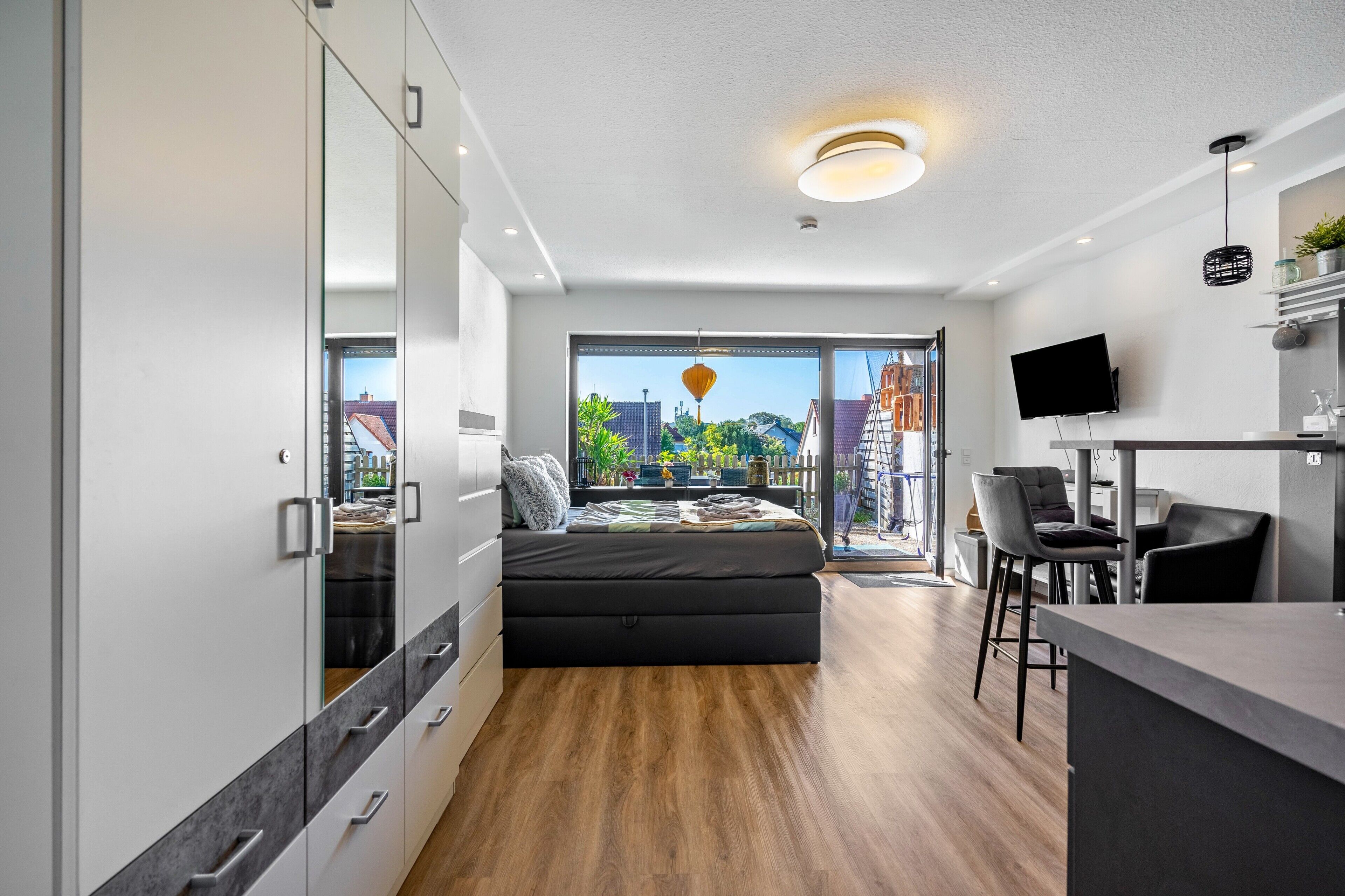 Ein modernes Schlafzimmer mit einem Bett, einem Schreibtisch und einem Fernseher.