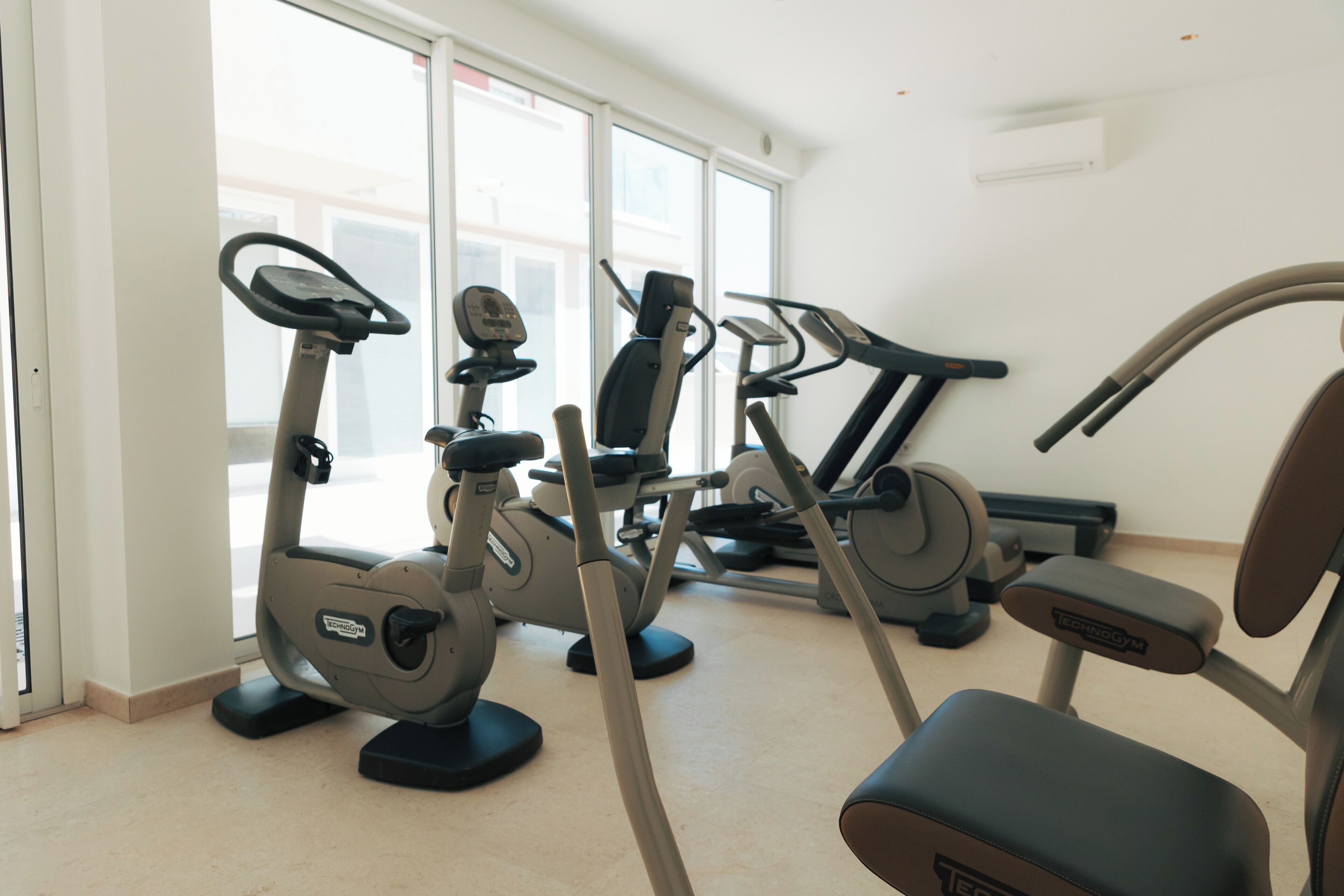 Ein Fitnessstudio mit Ergometer, Crosstrainer und Laufband.