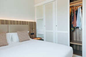 A hotel room with a bed, a nightstand, a wardrobe, and a mirror.