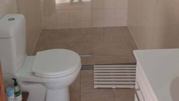 Un baño con ducha, inodoro y bañera.