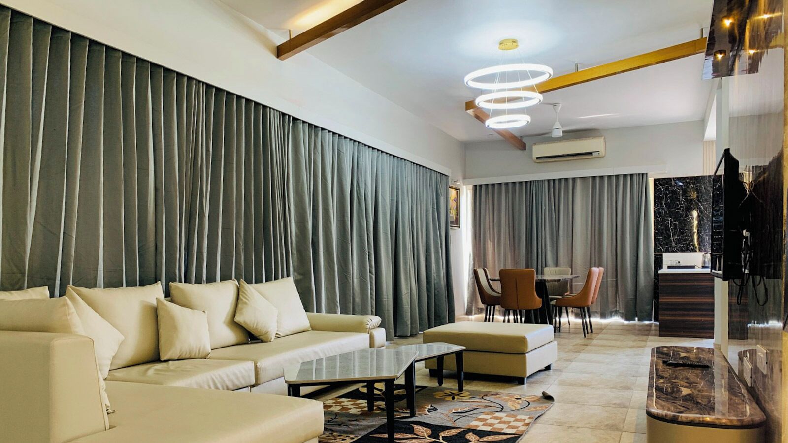 A modern living room with a sofa, coffee table, and dining area.