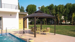 A swimming pool with a gazebo and outdoor seating area. - Kings Villa (Bavla)