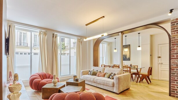 A modern living room with a sofa, armchairs, and a dining area. - Exceptional apartment with AC - Heart of Paris (Paris)