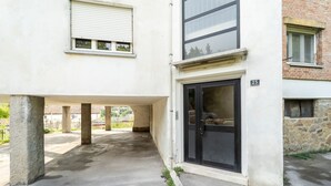 Un bâtiment doté d’un espace extérieur abrité, d’une porte avec une plaque portant un numéro et d’une fenêtre avec des stores.
