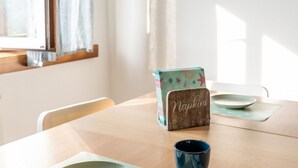 Une table en bois sur laquelle se trouve une boîte étiquetée « Serviettes » et une tasse bleue.