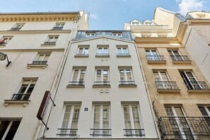 Een meerlaags gebouw met een klassieke architectuur, herkenbaar aan de symmetrische ramen en balkons.