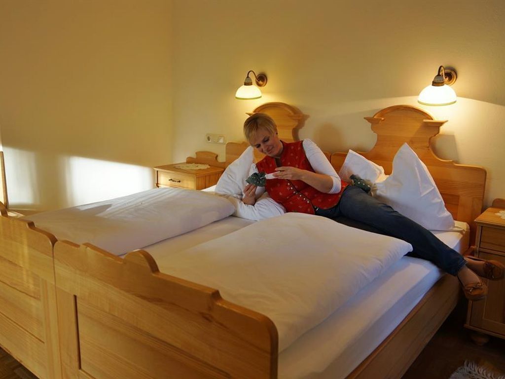A wooden bed with two nightstands, each with a lamp.
